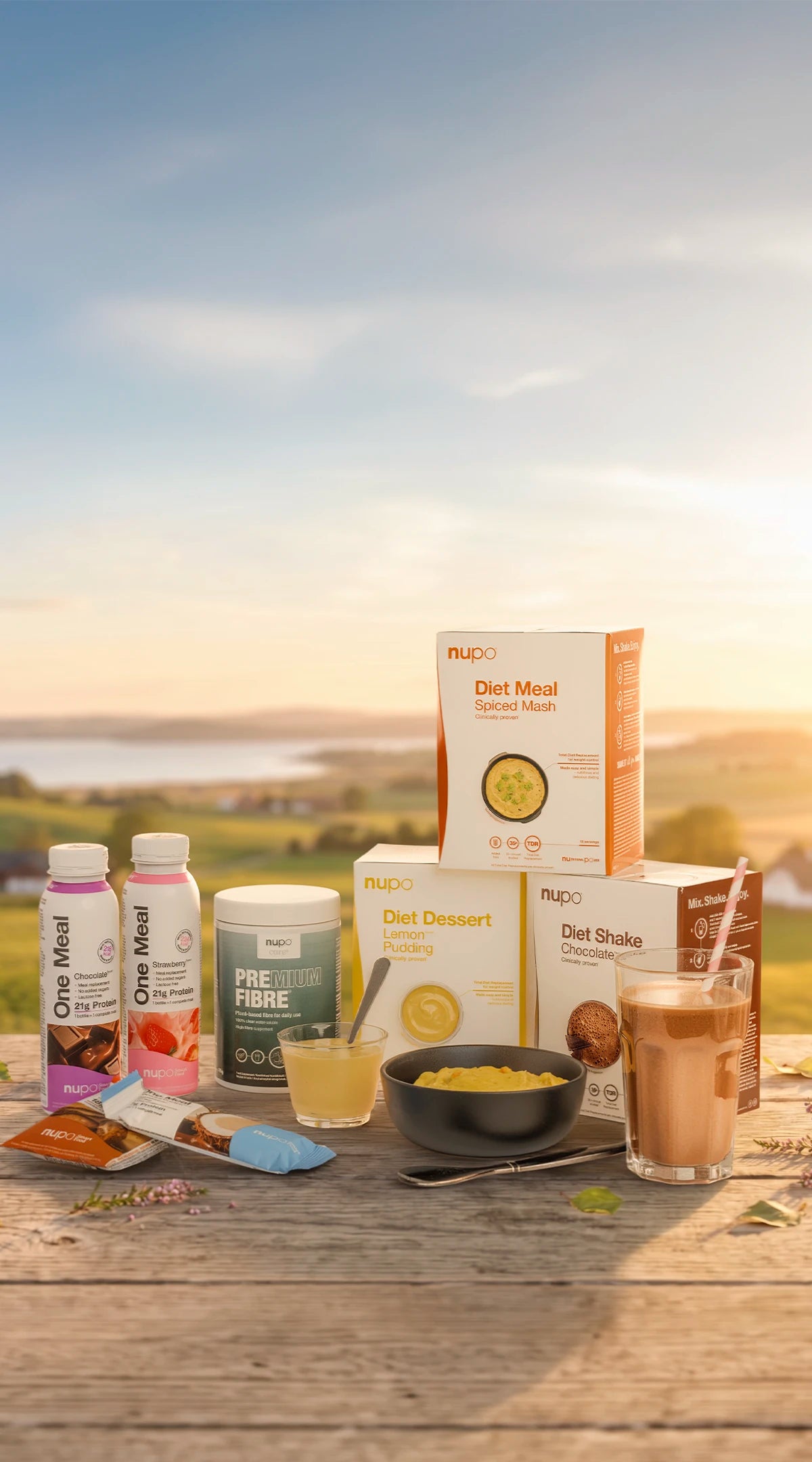 Various Nupo diet meal products displayed outdoors, including shakes, desserts, and ready-to-drink options.